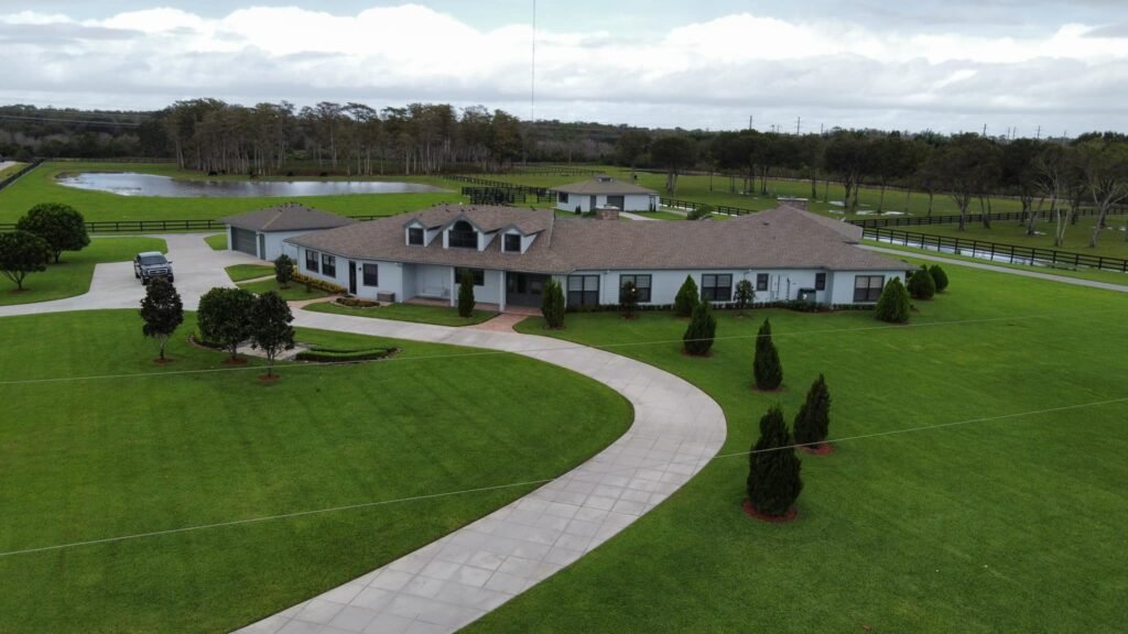 Aerial view of a freshly painted estate home with a circular driveway in Palm Beach County